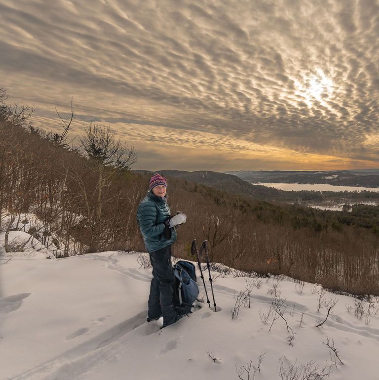 snowshoer enjoying view atop hill snowshoer enjoying view atop hill