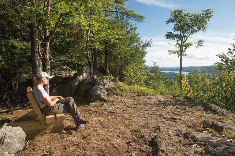 hiker on a wooden bench next to the trail hiker on a wooden bench next to the trail